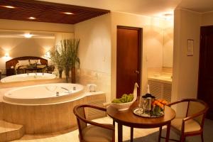 a bathroom with a tub and a table and chairs at Hotel Park Suites in Lima