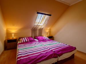 sypialnia z dużym łóżkiem z różową i fioletową pościelą w obiekcie Apartment Yucca 2 by Interhome w Zamárdi