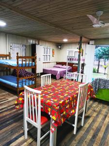 Pokój ze stołem, krzesłami i łóżkami piętrowymi w obiekcie Casa com churrasqueira wi-fi, Tv com Netflix e YouTube w mieście Balneário Gaivotas