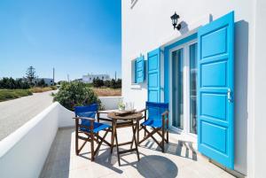 d'un balcon avec des portes bleues, une table et des chaises. dans l'établissement Domus Litus, à Pollonia