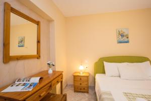 a bedroom with a bed and a mirror and a wooden dresser at Limonero New City Apartment 1 with Private Parking in Lefkada