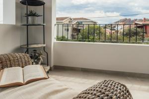 a book on a bed in a room with a window at B&B Antico Telaio in Santa Maria Navarrese