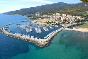 una vista aerea di un porto turistico con barche in acqua di L'Alizia a Sari Solenzara