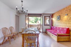 sala de estar con sofá rojo y mesa en Le Chevreuil - 3 chambres, terrasse, piscine, en Flumet