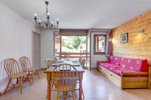 a living room with a red couch and a table at Le Chevreuil - 3 chambres, terrasse, piscine in Flumet