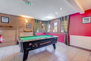 a pool table in a room with red walls at Le Chevreuil - 3 chambres, terrasse, piscine in Flumet