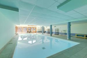 a large swimming pool in a large building at Le Chevreuil - 3 chambres, terrasse, piscine in Flumet