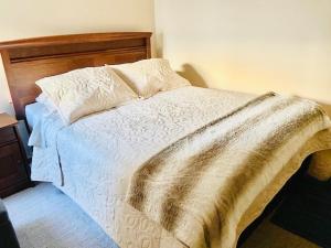 Un dormitorio con una cama con una manta. en Departamento Temuco Full Equipado en Temuco