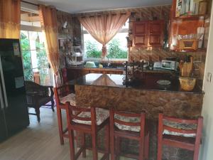a kitchen with a counter and some chairs in a room at Kai Selfcatering in La Digue