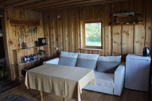 a living room with a couch and a table at Beautiful private cabin near Tartu in Külitse
