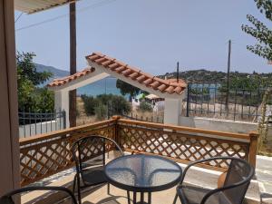 una mesa y sillas en un balcón con vistas al océano en ILIAKTI RELAXING SEASIDE, en Salamina