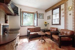 un soggiorno con mobili in pelle e camino di Stabol Cottage a Tremosine Sul Garda