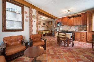 un soggiorno con tavolo e sedie e una cucina di Stabol Cottage a Tremosine Sul Garda
