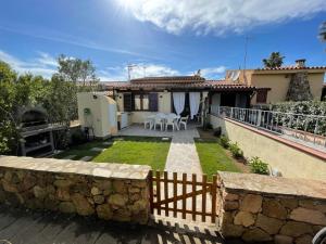 una casa con una valla de piedra y un patio en Splendida Villetta San Teodoro en San Teodoro