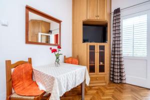 a dining room table with a vase of flowers on it at Apartments Kazo in Dubrovnik