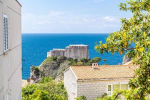 a castle on a hill next to the ocean at Apartments Kazo in Dubrovnik
