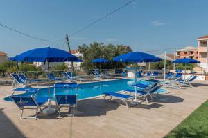 einen Pool mit blauen Stühlen und Sonnenschirmen in der Unterkunft Porto Samaria holiday resort in Trogir