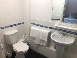 a white bathroom with a toilet and a sink at Whalley Abbey - Christian Retreat House offering B&B in Whalley