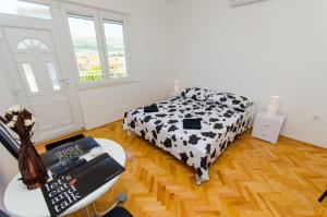 a bedroom with a black and white bed and a table at Apartments Ivana in Trogir