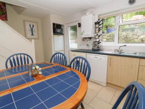 a kitchen and dining room with a blue table and chairs at 8 Bowjey Terrace in Penzance