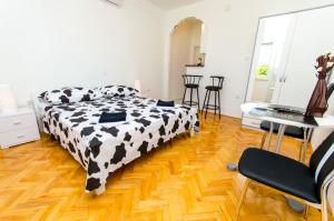 a bedroom with a black and white bed and a desk at Apartments Ivana in Trogir