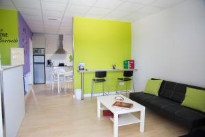 a living room with a black couch and a green wall at Albergue Camiño Do Sar in Padrón