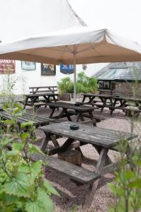 a group of picnic tables with an umbrella at Beautiful 1-Bed Cottage in Trellech in Trelleck