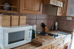 a kitchen with a microwave on top of a counter at Beautiful 1-Bed Cottage in Trellech in Trelleck +8 photos