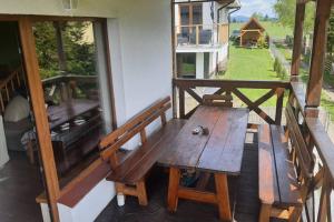 a wooden bench sitting on a porch with a table at Domek na Polnej in Czorsztyn