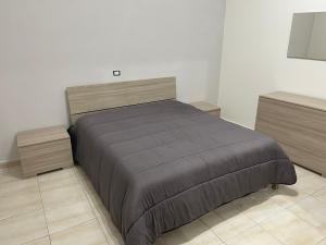 een slaapkamer met een groot bed en 2 dressoirs bij A Casa di Mimia in Avellino