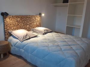 Le Bouchatou (meublé touristique neuf)*** في Saint-Front: غرفة نوم بسرير كبير مع اللوح الخشبي الكبير