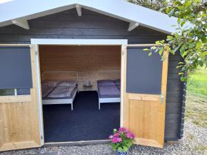 un grand hangar en bois avec un lit et une table dans l'établissement Camping Weides, à Küps