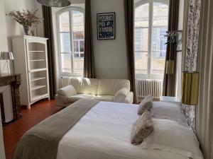 a bedroom with a bed and a couch and windows at La maison d’arles in Arles