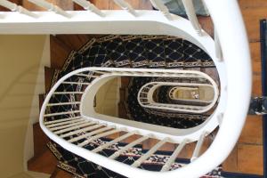 a spiral staircase with black and white treads at Duc de Bretagne Luxury Apparthotel in Morlaix