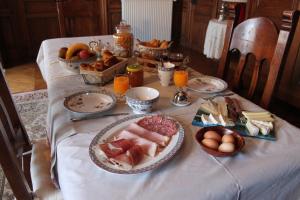 una mesa con platos de comida y fruta. en Le Château de Vernières en Talizat