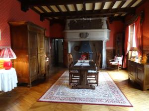 a dining room with a table and a fireplace at Le Château de Vernières in Talizat