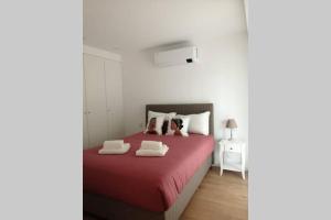 a bedroom with a red bed with two pillows at CAIS DE APRESENTAÇÃO NO CORAÇÃO DE AVEIRO in Aveiro