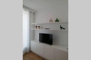 a living room with a tv on a white wall at CAIS DE APRESENTAÇÃO NO CORAÇÃO DE AVEIRO in Aveiro