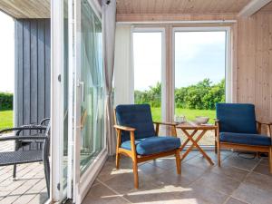 a screened porch with two chairs and a table at 8 person holiday home in Hemmet in Falen