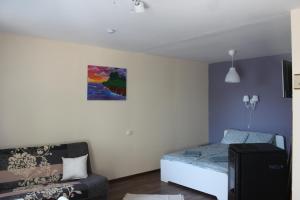 una piccola camera con letto e divano di White box apartment a Liepāja