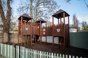 une aire de jeux en bois dans un parc avec une clôture dans l'établissement The Brewers Inn, à Milton