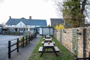 une rangée de bancs devant un bâtiment dans l'établissement The Brewers Inn, à Milton