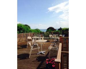 un patio con mesas y sillas en una terraza en Richmond Hotel, en Torquay