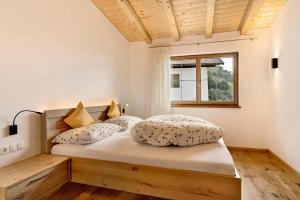 ein Schlafzimmer mit einem Bett mit zwei Kissen darauf in der Unterkunft Unterötzbauerhof - Fewo Rosenblick in Dorf Tirol