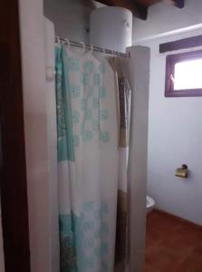 a bathroom with a shower curtain and a toilet at Casita Adela in Huéscar