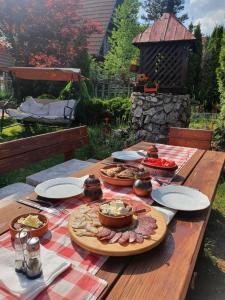 a wooden table with plates of food on it at Ethno Homestay Savić in Vodice