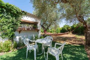 a table and chairs in the yard of a house at Villa L'Oliveto in Oliena