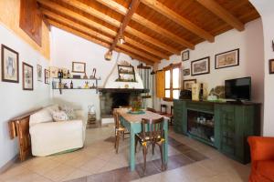 uma sala de estar com uma mesa e uma lareira em Villa L'Oliveto em Oliena