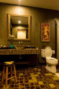 
a bathroom with a toilet a sink and a mirror at Arun Residence in Bangkok
