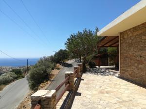 a building with a bench next to a road at Stone House in Triopetra